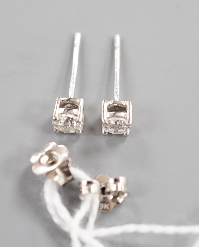 A modern pair of 9ct white gold and solitaire diamond set ear studs, gross 0.8 grams